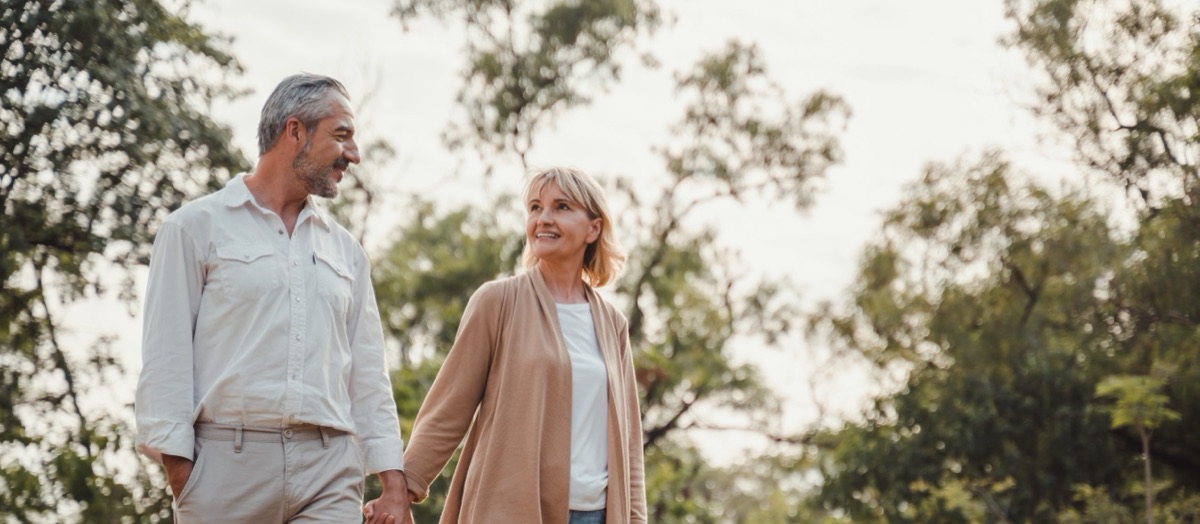 Pareja de adultos mayores caminando por un parque