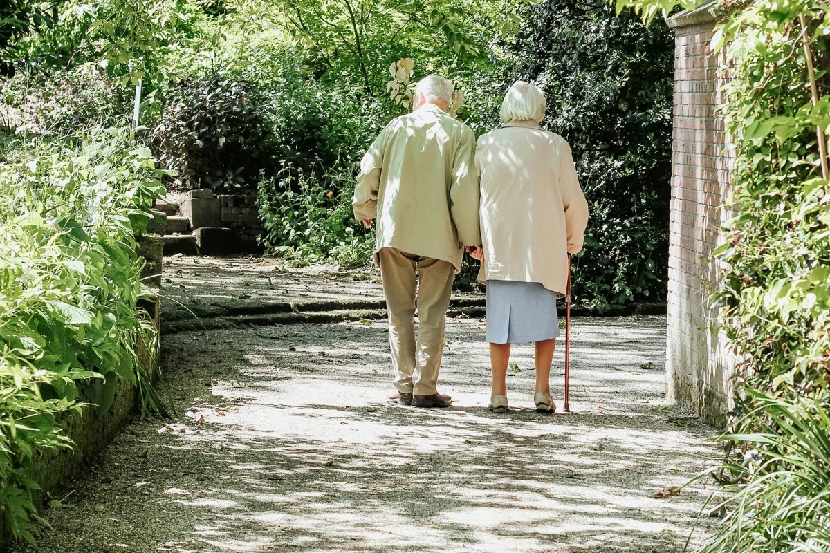 Pareja mayor caminando de la mano por un sendero
